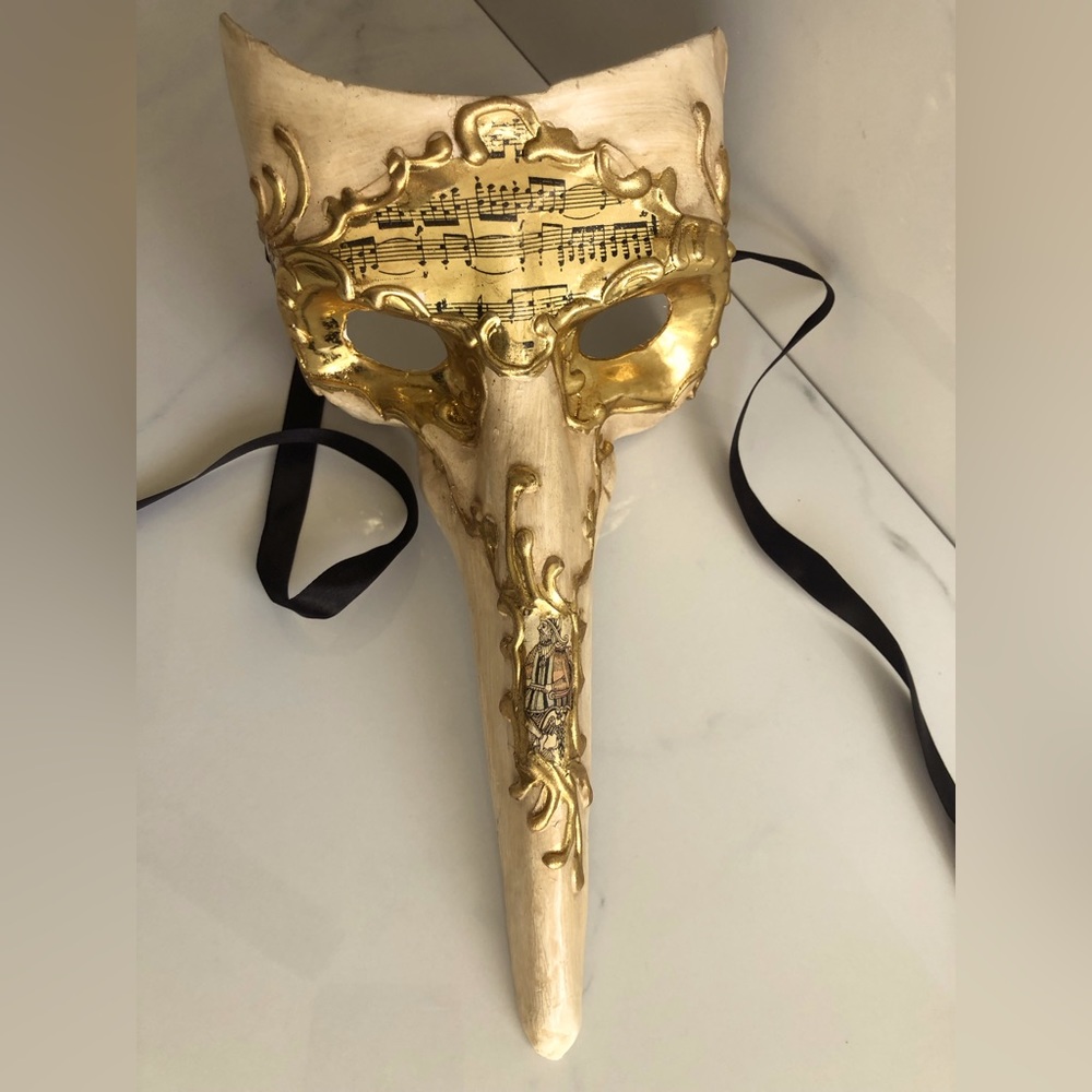 Gorgeous masquerade mask with long protruding nose, and beautiful gold details.